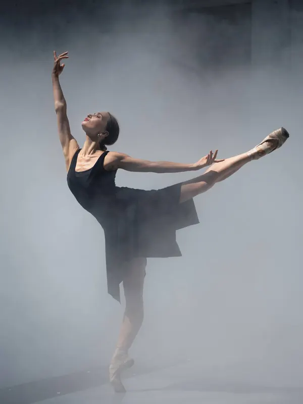 Zuza in an arabesque in a misty studio
