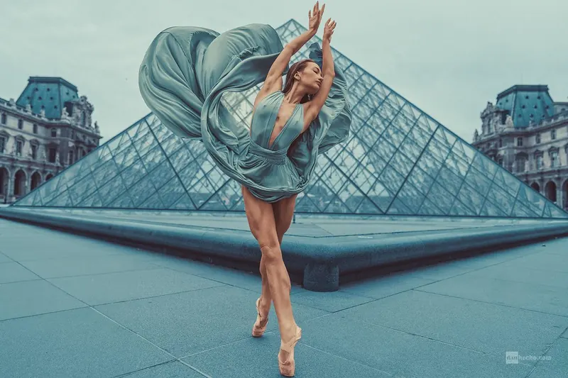 Zuza dancing on pointe by the Louvre pyramid, her skirt in the air